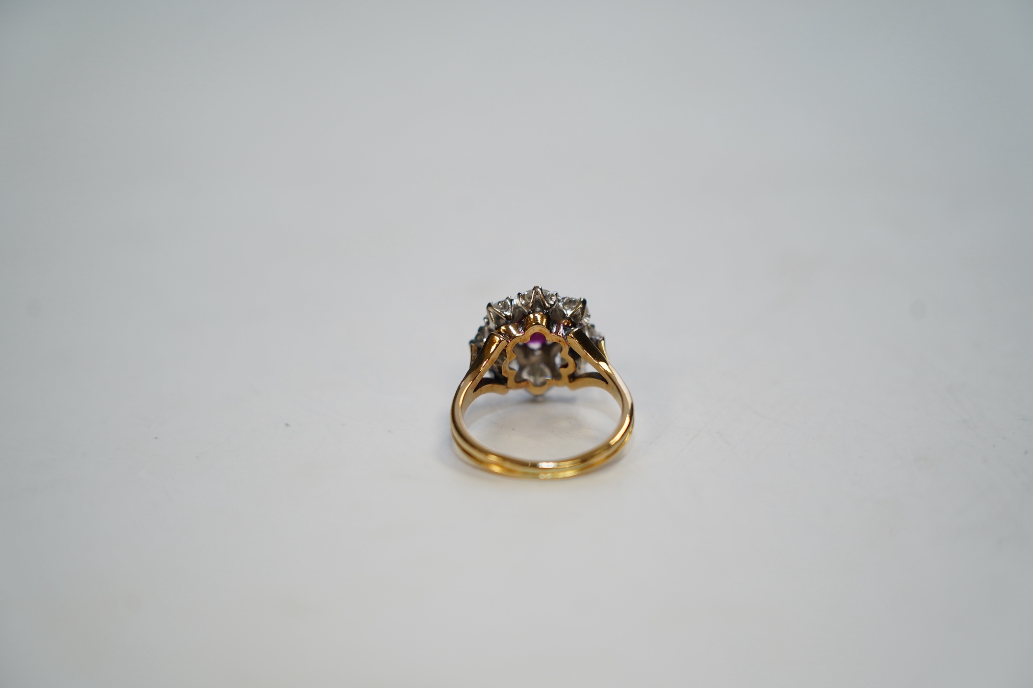 An 18ct gold, single stone ruby and eight stone diamond set flower head cluster ring, size P, gross weight 6.5 grams. Condition - fair